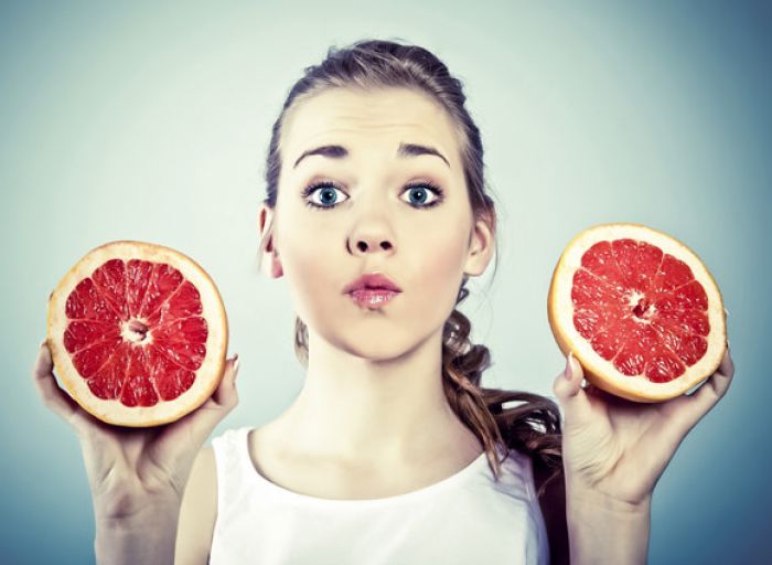 young-girl-holding-sliced-grapefruit