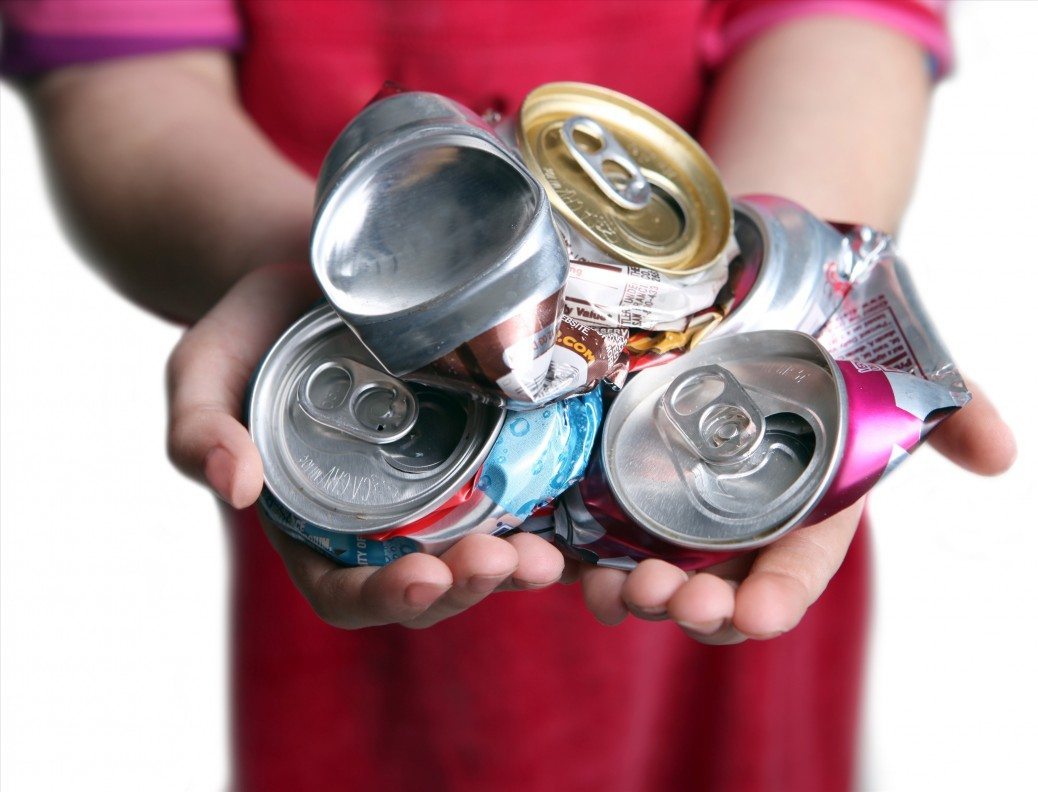 Young Child Holding Crushed Aluminum Cans Representing Concept to Recycle for Their Future